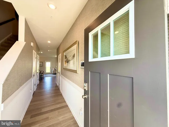 a view of a hallway with wooden floor and windows