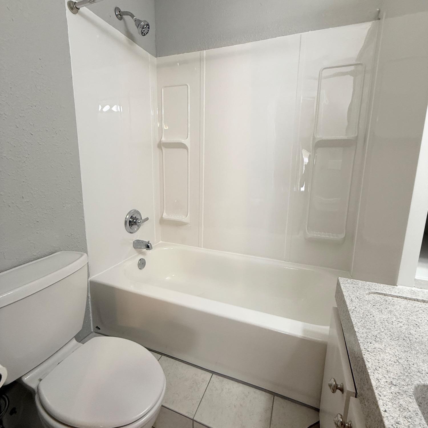 2806 54th Street Lubbock, TX 79413 - Photo 13 of 23 a bathroom with a toilet and a bath tub