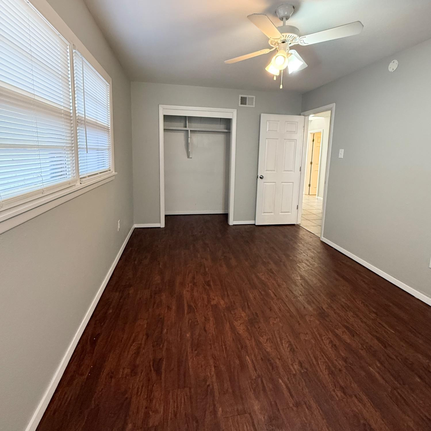 2806 54th Street Lubbock, TX 79413 - Photo 17 of 23 an empty room with wooden floor fan and windows