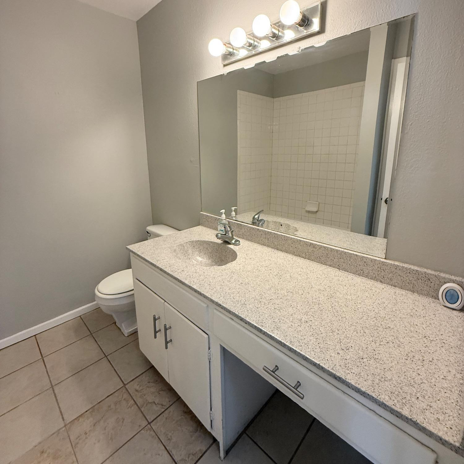 2806 54th Street Lubbock, TX 79413 - Photo 18 of 23 a bathroom with a sink a toilet and a mirror