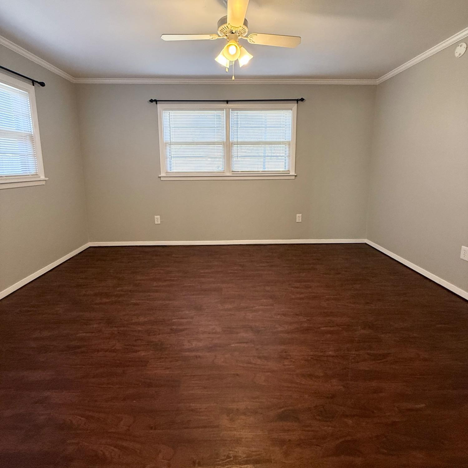 2806 54th Street Lubbock, TX 79413 - Photo 21 of 23 an empty room with wooden floor chandelier fan and windows