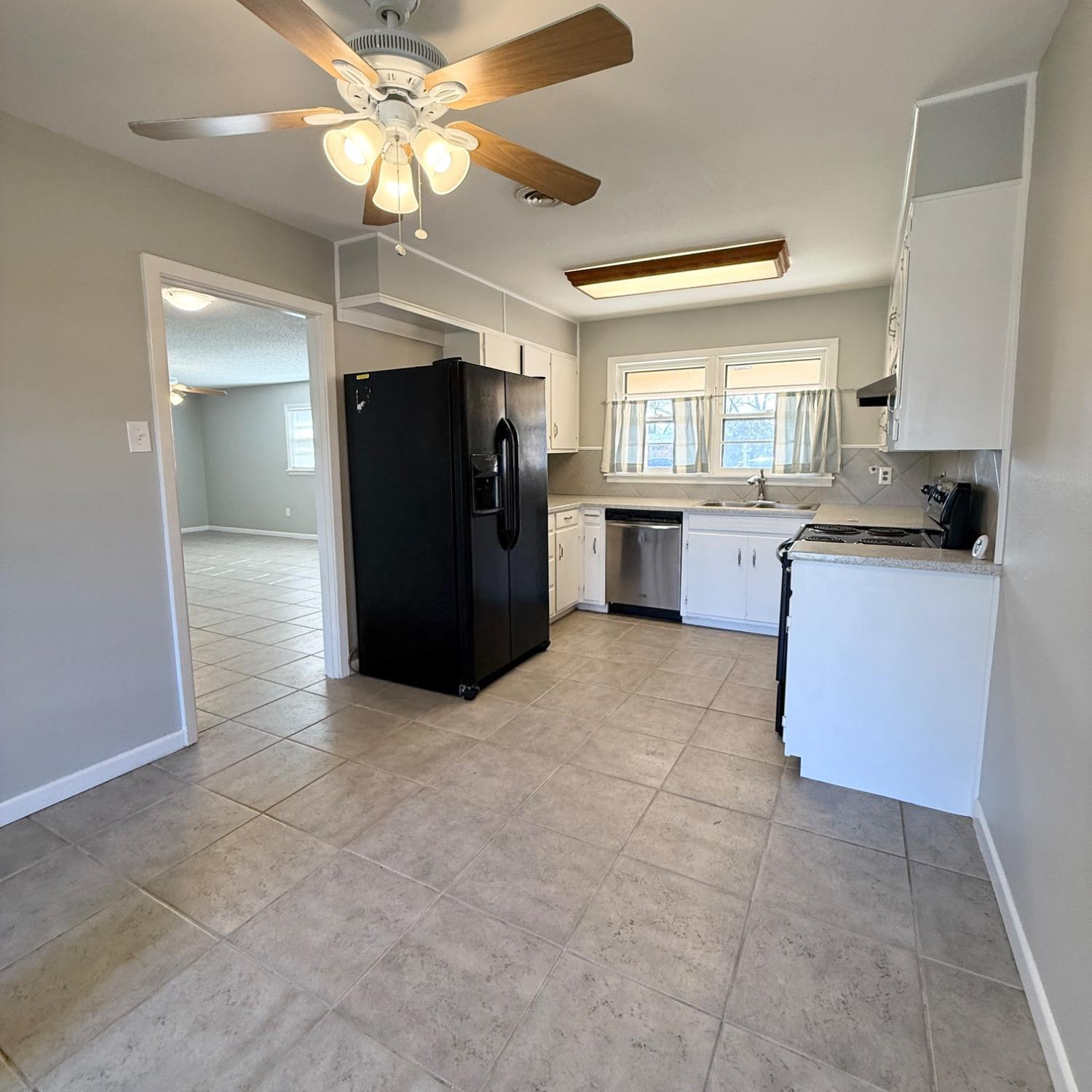 2806 54th Street Lubbock, TX 79413 - Photo 6 of 23 a kitchen with granite countertop a refrigerator and a stove top oven