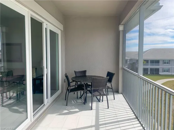 a balcony with chairs and glass door