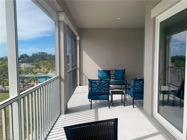 a living room with furniture and a floor to ceiling window