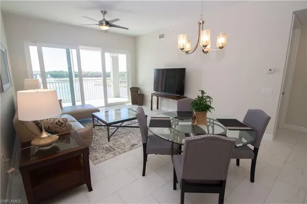 a living room with furniture a chandelier and a flat screen tv