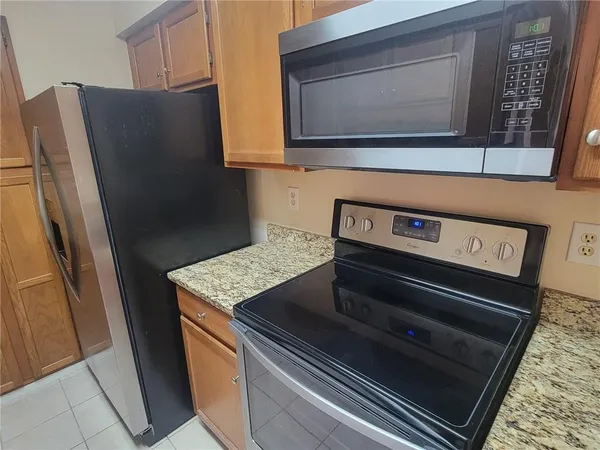 a kitchen with stainless steel appliances granite countertop a refrigerator stove and sink