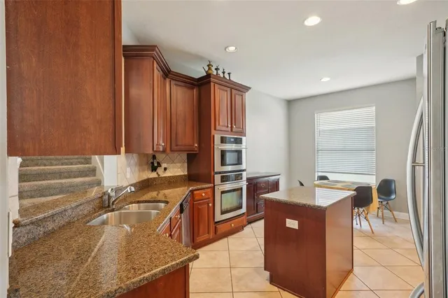a kitchen with stainless steel appliances granite countertop a stove top oven a sink and dishwasher