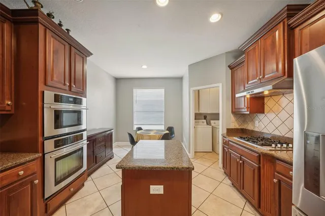 a kitchen with granite countertop a sink stove and cabinets