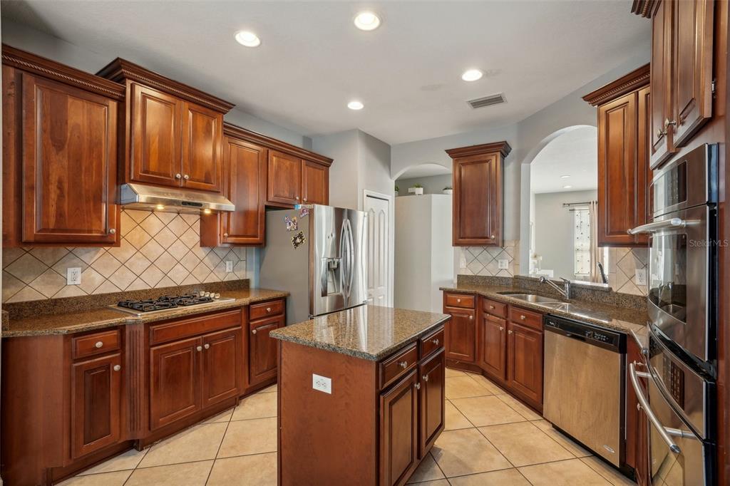 16751 Taylow Way Odessa, FL 33556 - Photo 18 of 54 a kitchen with stainless steel appliances granite countertop a stove refrigerator and cabinets