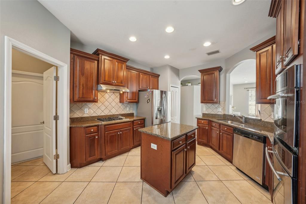 16751 Taylow Way Odessa, FL 33556 - Photo 19 of 54 a large kitchen with stainless steel appliances granite countertop a stove and a refrigerator