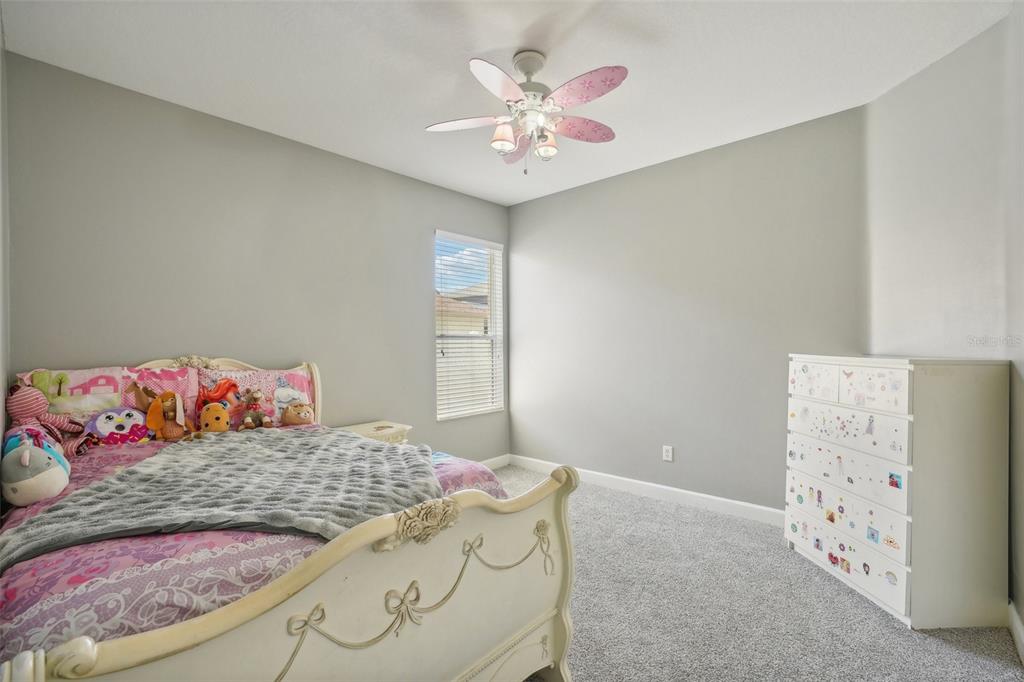 16751 Taylow Way Odessa, FL 33556 - Photo 29 of 54 a bedroom with a bed and a chandelier