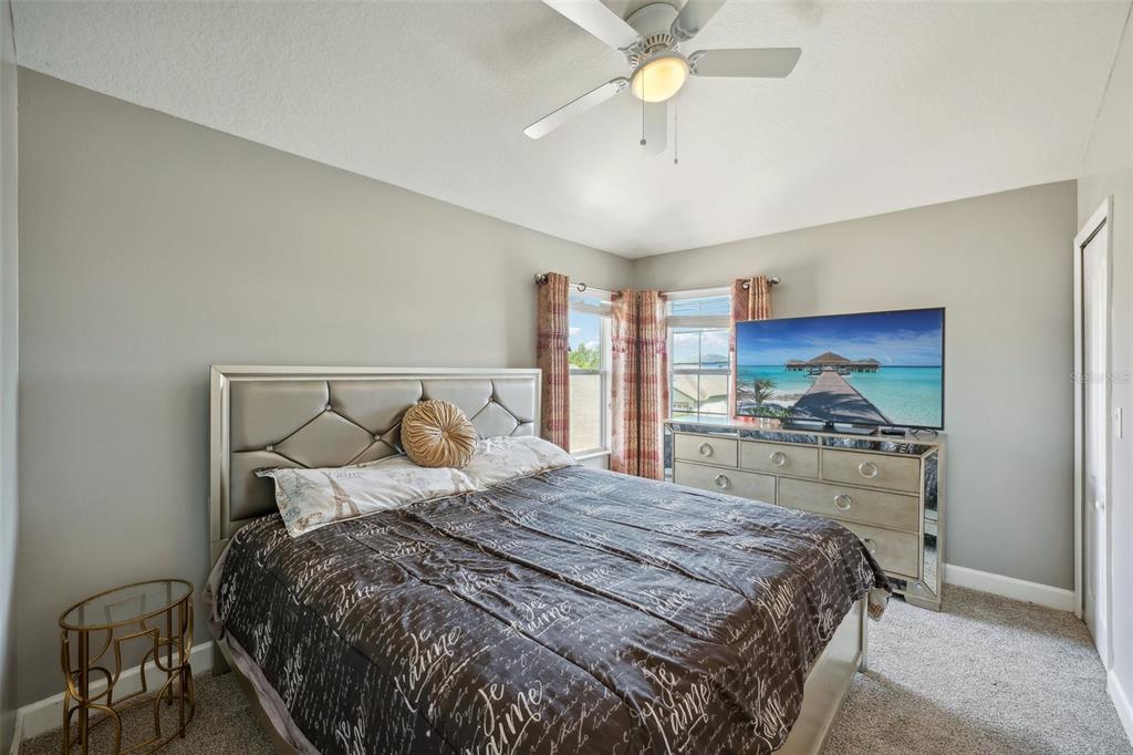 16751 Taylow Way Odessa, FL 33556 - Photo 49 of 54 a bedroom with a large bed and a chandelier