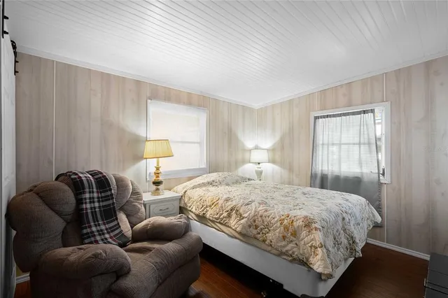 a bedroom with bed couch and window