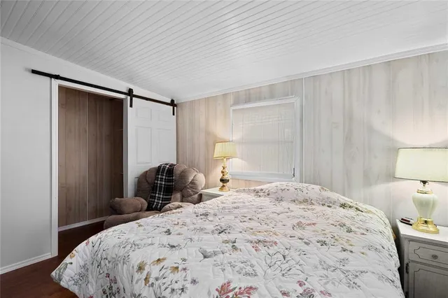 a bedroom with a bed and a lamp on dresser