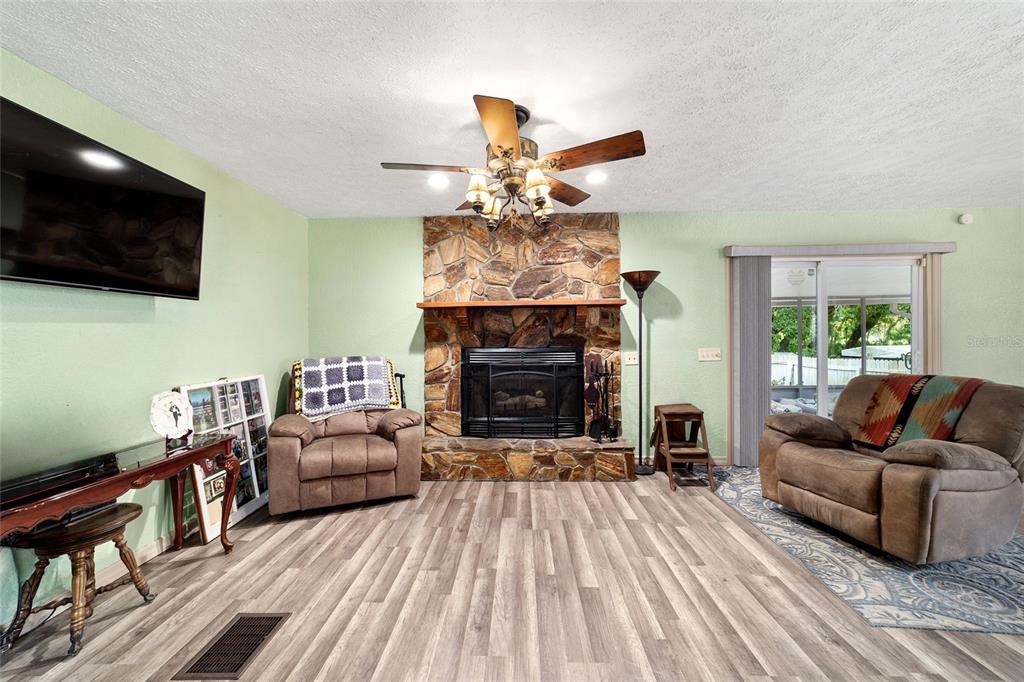 15755 Southwest 90th Avenue Dunnellon, FL 34432 - Photo 9 of 55 a living room with furniture a flat screen tv and a fireplace