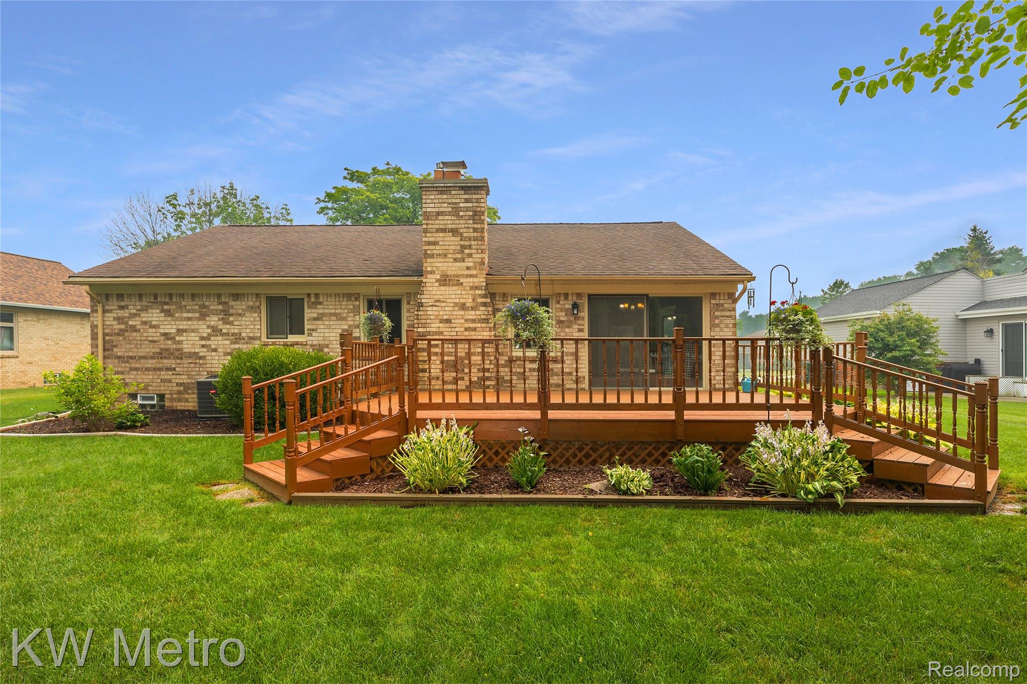 2154 Warrington Road Rochester, MI 48307 - Photo 3 of 41 Spacious elevated wood deck featuring dual staircases, decorative railings, and landscaping