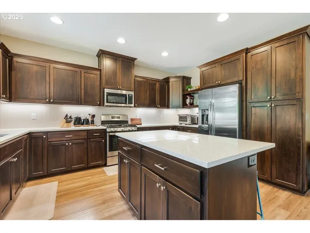 a kitchen with stainless steel appliances granite countertop a refrigerator stove a sink and dishwasher