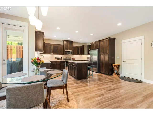 a kitchen with stainless steel appliances kitchen island granite countertop a refrigerator and a stove top oven
