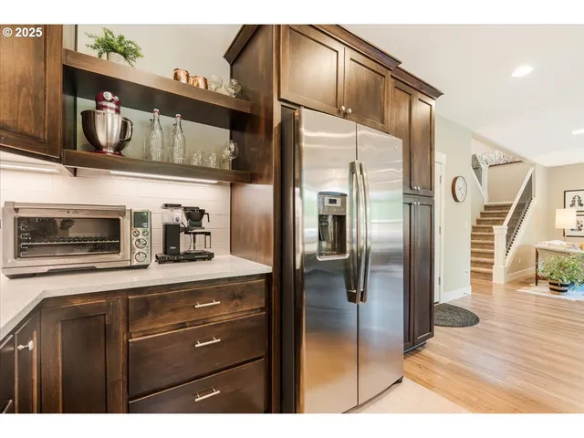 a kitchen with stainless steel appliances kitchen island granite countertop a refrigerator and cabinets