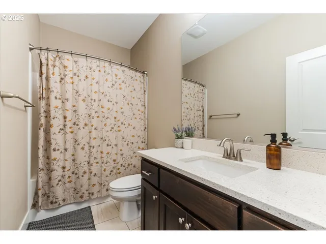 a bathroom with a sink a toilet and shower curtain