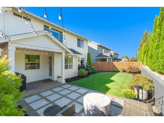 a front view of a house with a yard and potted plants
