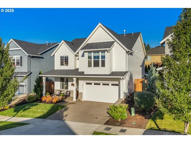 a front view of a house with a yard and potted plants