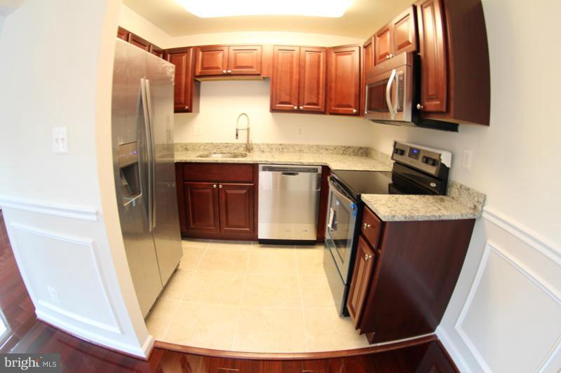 2611 Harris Avenue Silver Spring, MD 20902 - Photo 12 of 30 a kitchen with stainless steel appliances granite countertop a sink a stove a microwave a refrigerator and cabinets