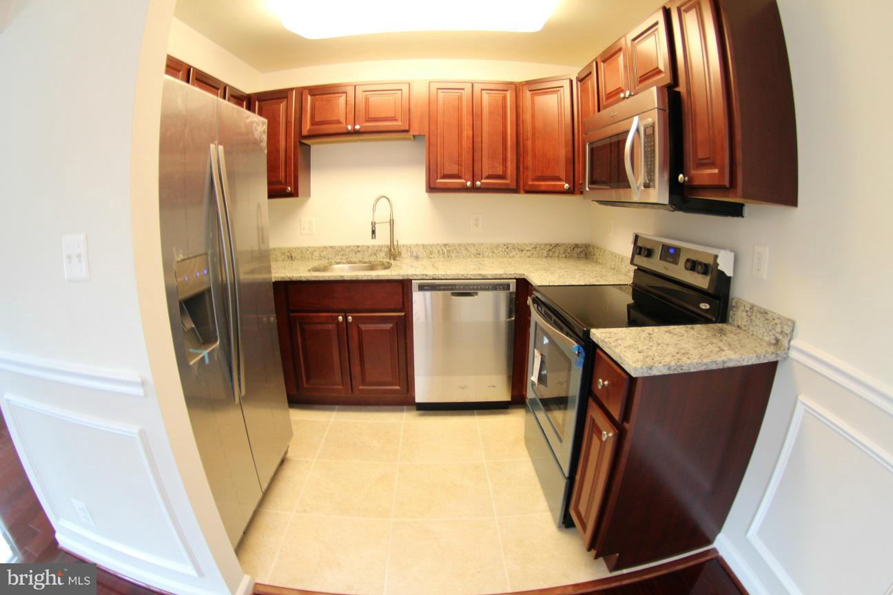 2611 Harris Avenue Silver Spring, MD 20902 - Photo 10 of 30 a kitchen with stainless steel appliances granite countertop a refrigerator a stove a sink and a microwave