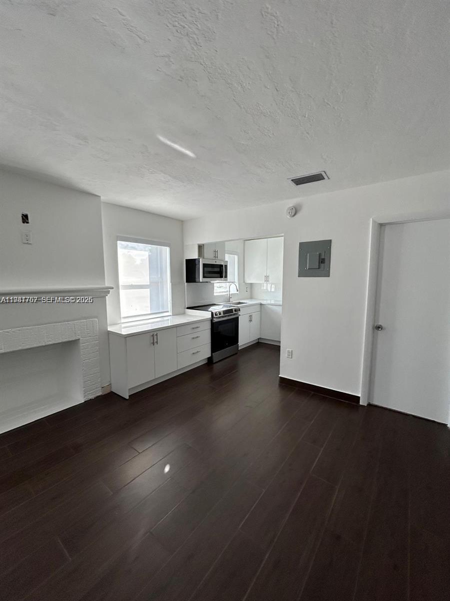 1810 Northwest 34th Street, Unit 2 Miami, FL 33142 - Photo 2 of 11 a view of an empty room with a window and wooden floor