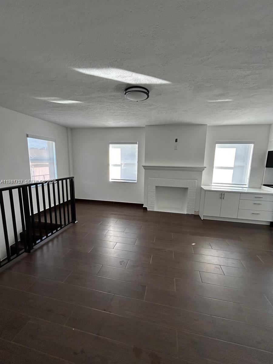 1810 Northwest 34th Street, Unit 2 Miami, FL 33142 - Photo 9 of 11 an empty room with wooden floor windows and windows