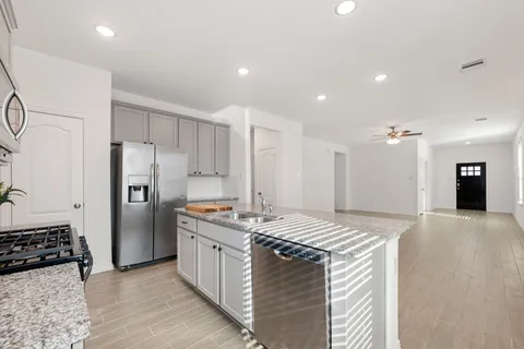 a kitchen with stainless steel appliances granite countertop a sink stove and refrigerator