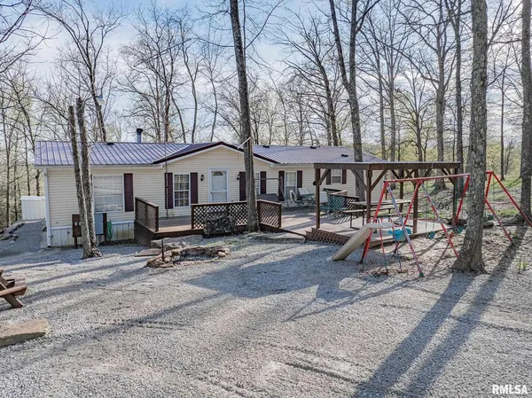 a small house with a bench and trees