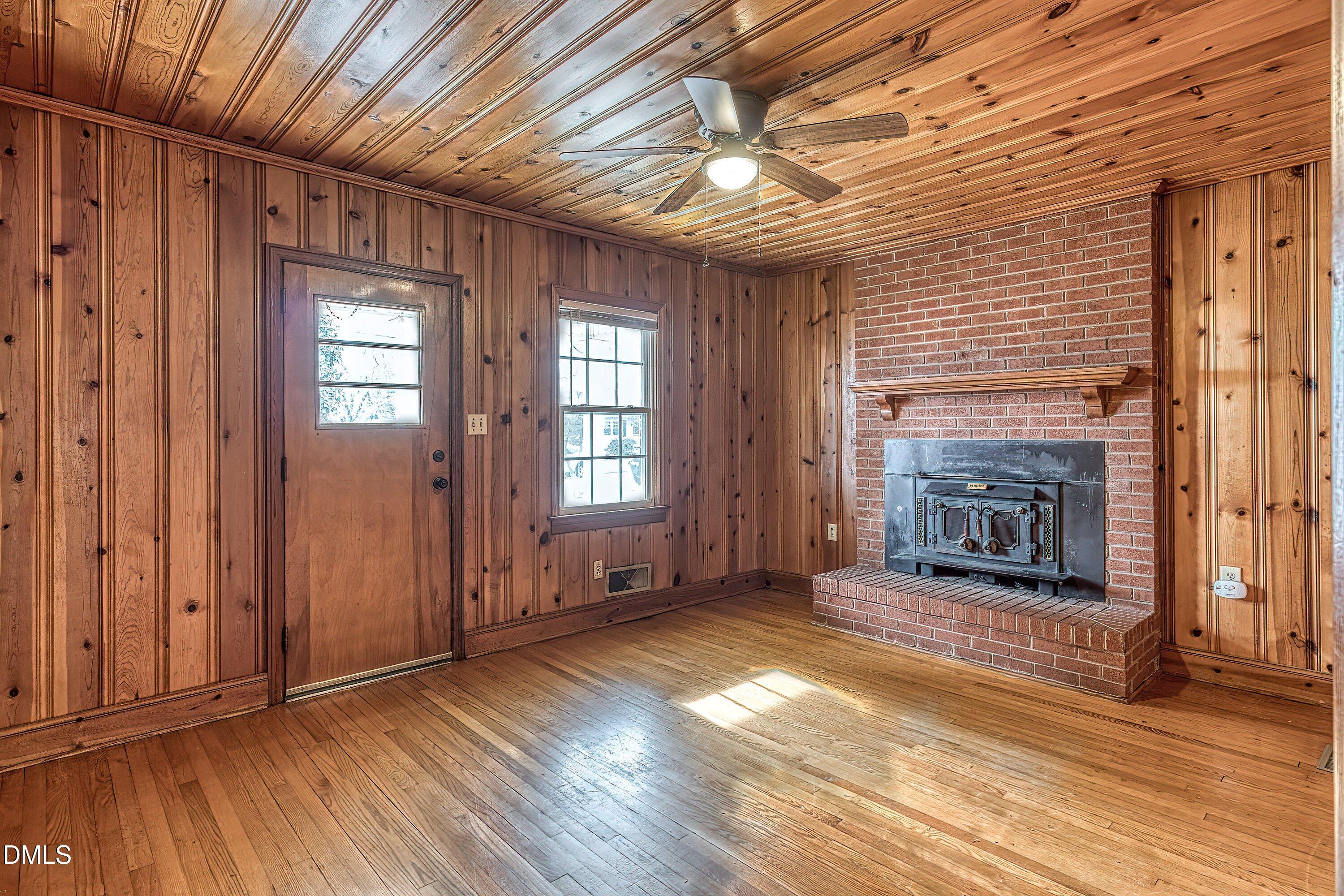 629 East Main Street Clayton, NC 27520 - Photo 16 of 39 an empty room with wooden floor fireplace and windows
