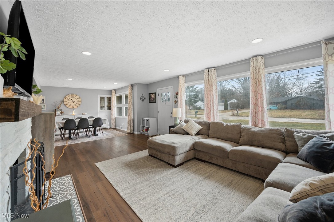 87 Kenridge Road Akron, OH 44333 - Photo 7 of 48 Living area with dark wood-style floors, a textured ceiling, a fireplace with flush hearth, and recessed lighting