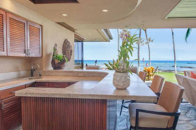 a kitchen with a table chair and potted plant