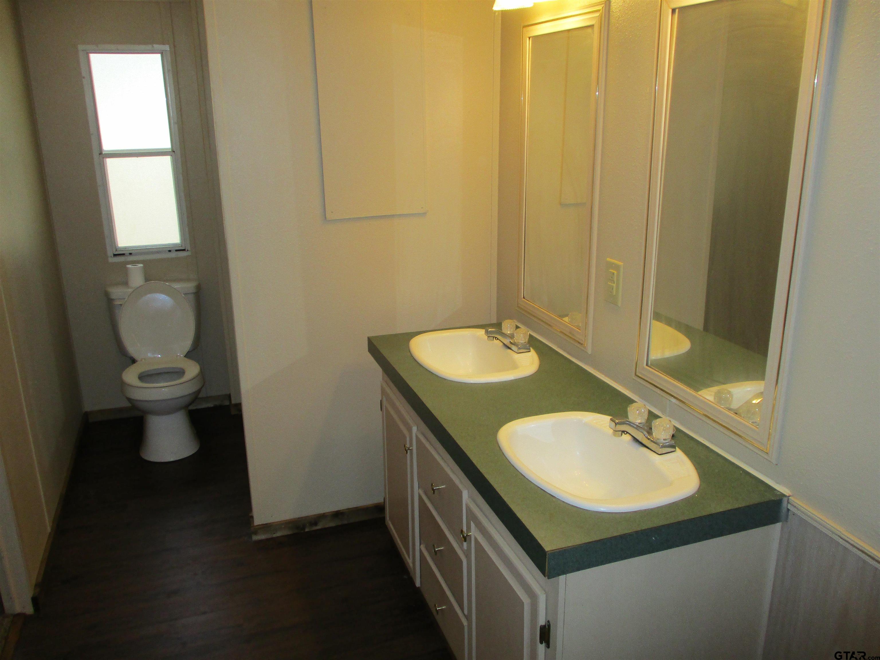 105 Sioux Lane Longview, TX 75603 - Photo 12 of 22 a bathroom with a sink toilet and a mirror