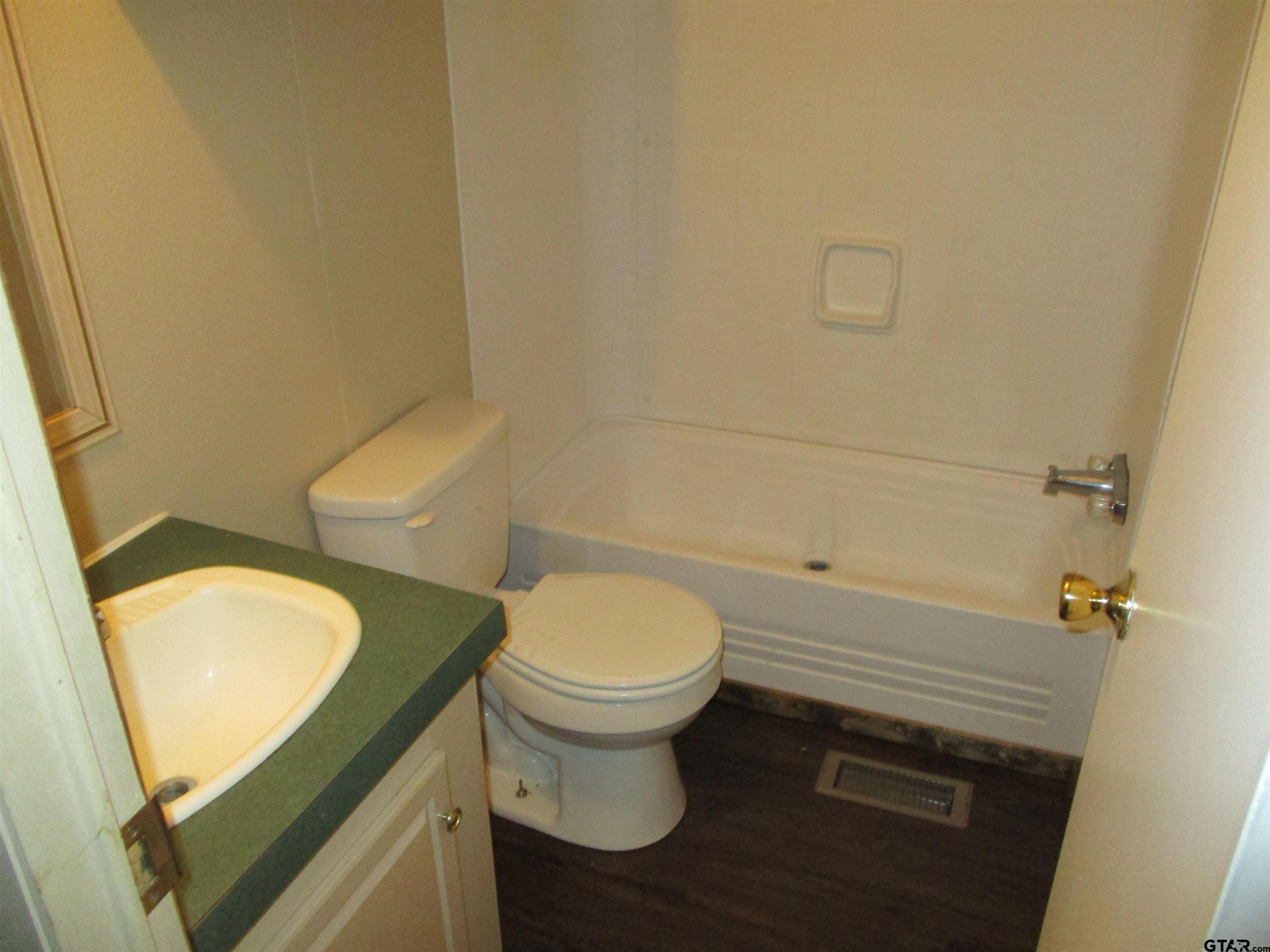 105 Sioux Lane Longview, TX 75603 - Photo 17 of 22 a white toilet sitting next to a bathroom sink and a granite floor