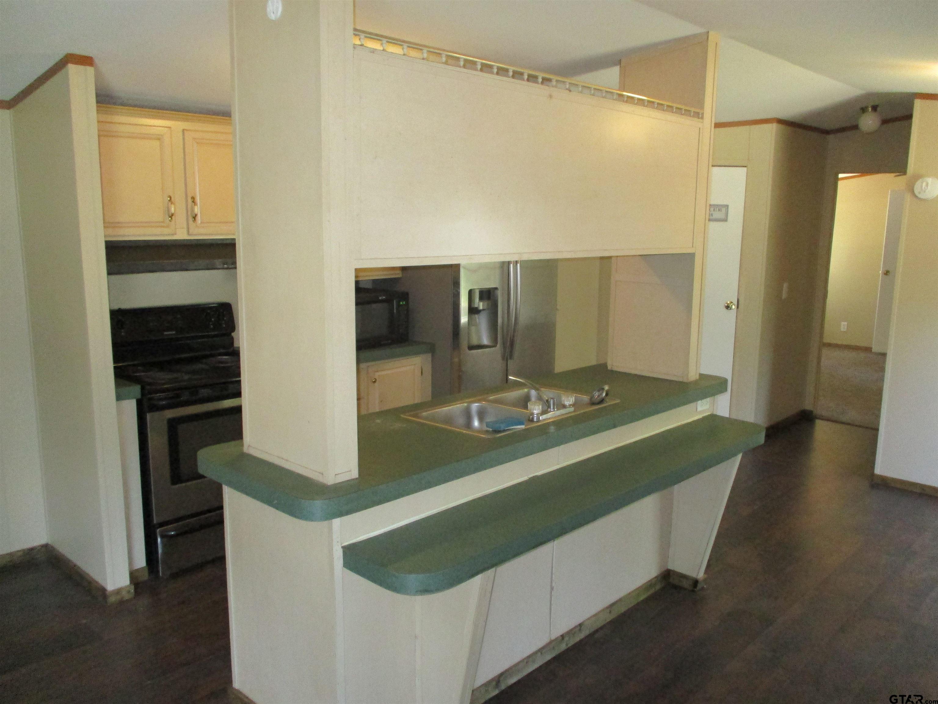 105 Sioux Lane Longview, TX 75603 - Photo 22 of 22 a kitchen with a sink and a refrigerator