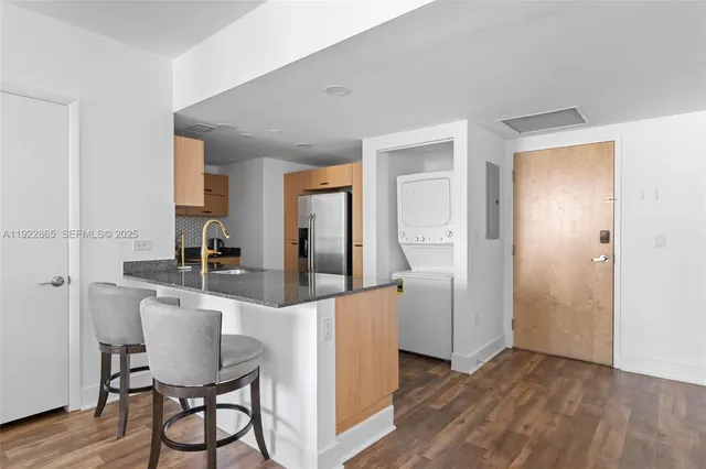 a kitchen with kitchen island granite countertop a sink and refrigerator