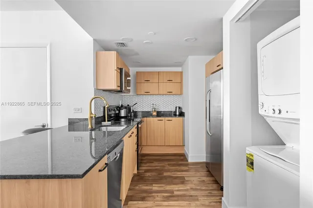 a kitchen with stainless steel appliances granite countertop a sink stove and refrigerator