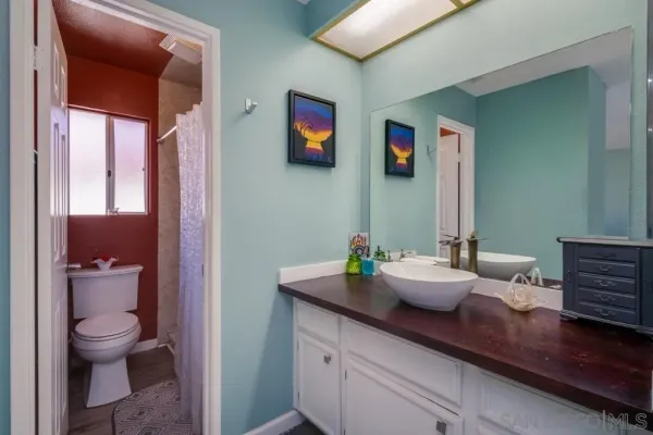 a bathroom with a granite countertop sink mirror and toilet