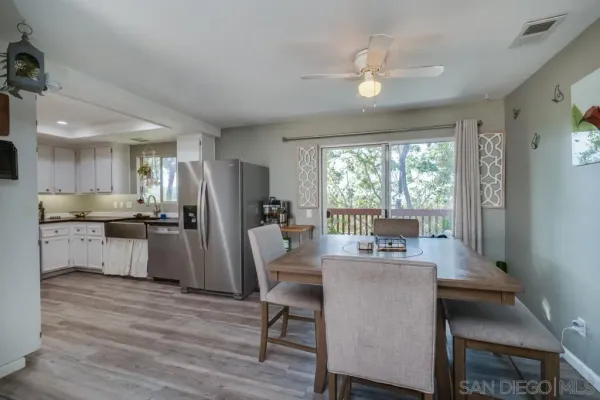 a dining room with furniture and a floor to ceiling window
