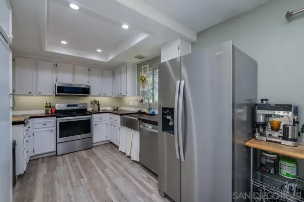 a kitchen with granite countertop a refrigerator and a stove top oven