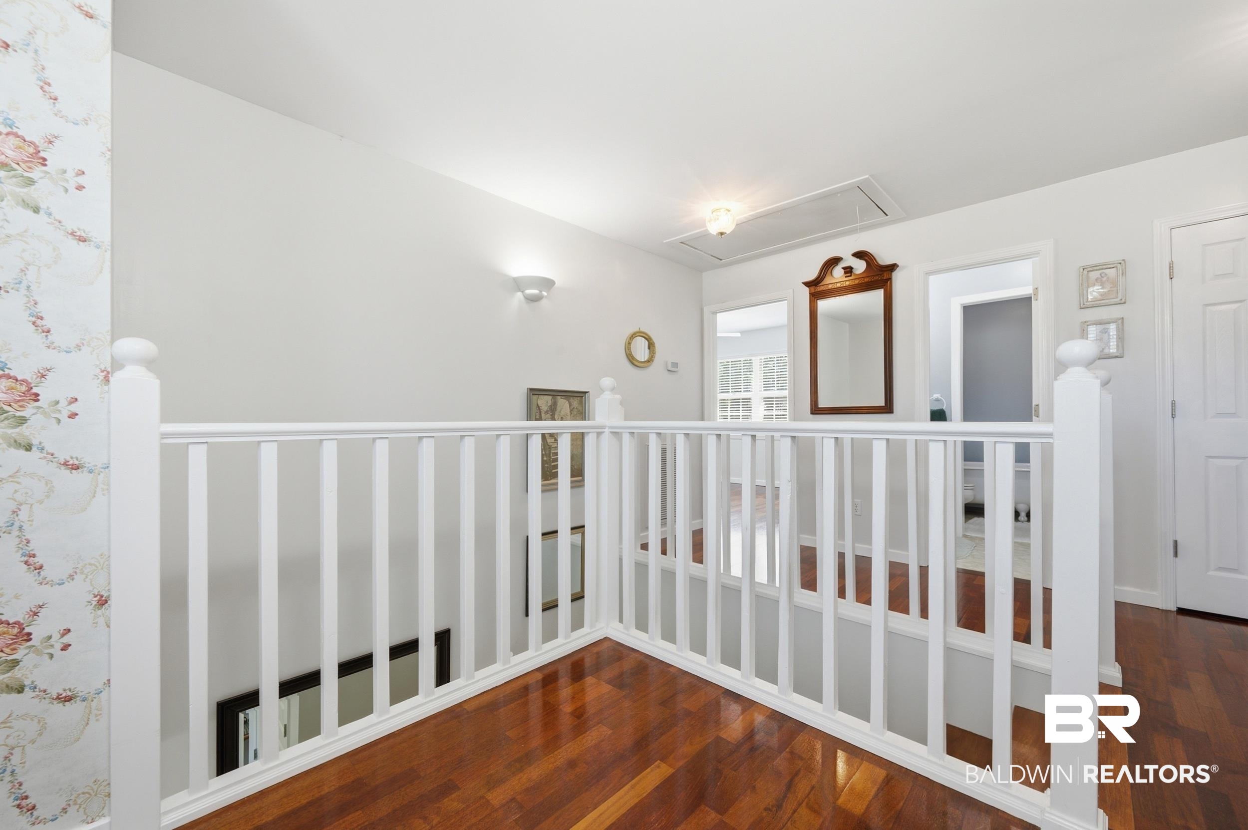 15855 Calvin Richerson Road Bay Minette, AL 36507 - Photo 54 of 83 Upper level landing featuring hardwood flooring, white baluster railing, and a vaulted ceiling