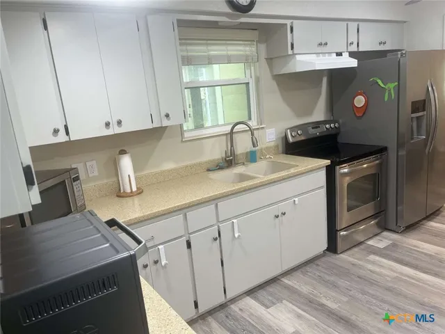 a view of a patio with a table and chairs next to a yard