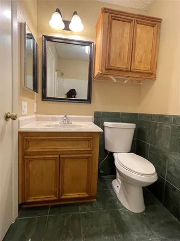 a bathroom with a toilet sink and mirror
