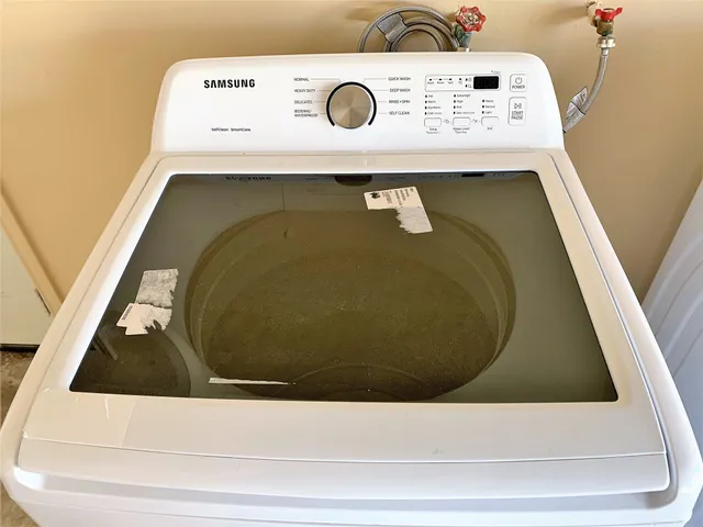 a utility room with a fridge and a white wall