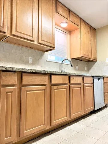 a kitchen with granite countertop white cabinets and a sink