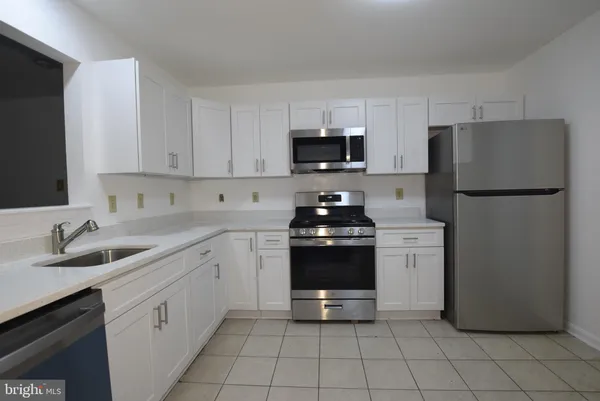 a kitchen with appliances a sink and cabinets