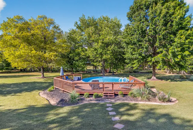a swimming pool with trees in the background